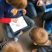 Kinder spielen am Tablet.