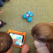 Kinder spielen mit Roboter.