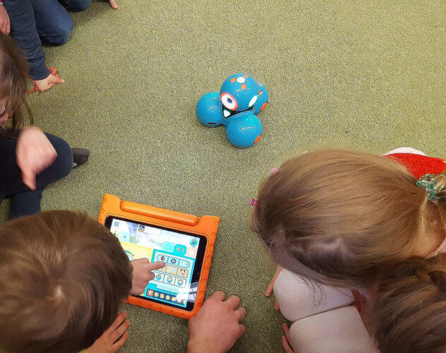 Kinder spielen mit Roboter.